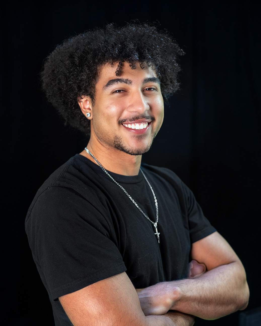 A smiling young man wearing a black t-shirt